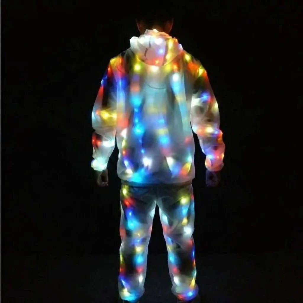 A person wearing a light-up neon costume jacket and pants set against a dark background.