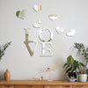 Decorative wall art featuring three-dimensional acrylic heart stickers with a mirror finish on a white wall.
