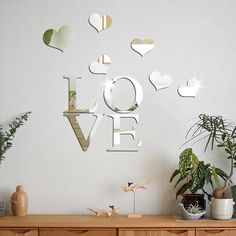 Decorative wall art featuring three-dimensional acrylic heart stickers with a mirror finish on a white wall.