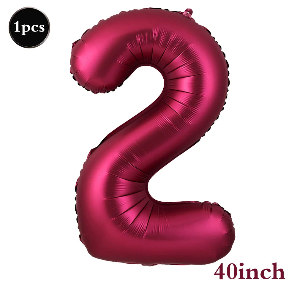 A single large, metallic pink foil number balloon shaped like the numeral 2.