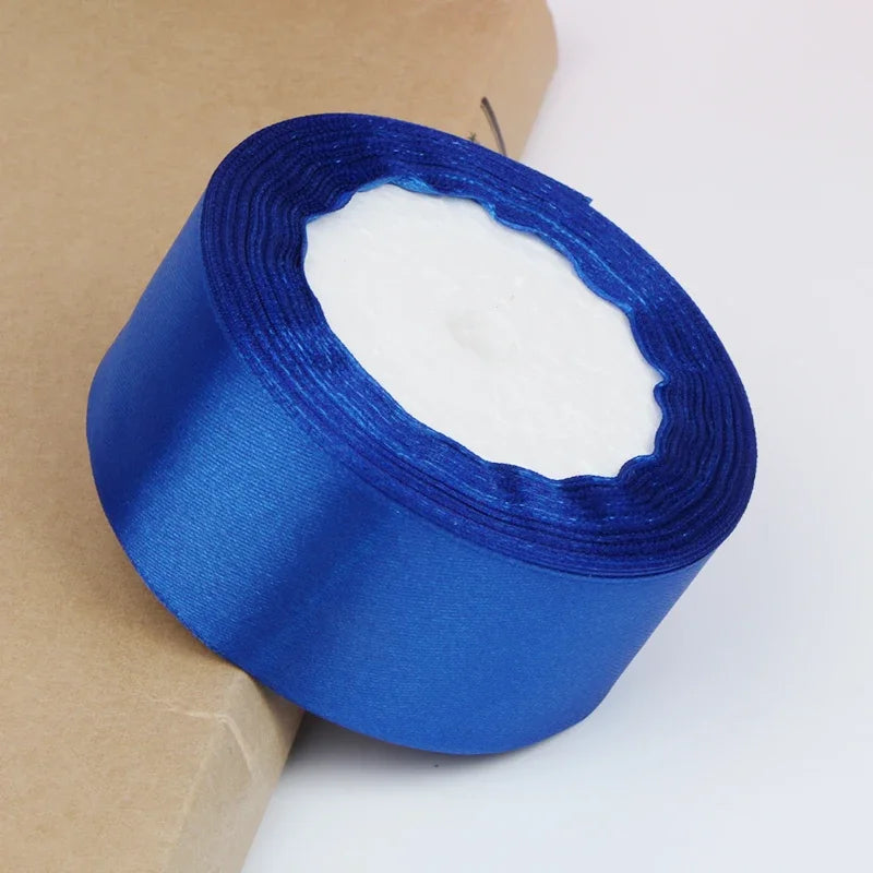 A roll of bright blue satin ribbon with a visible hole, used for crafts and gift wrapping.