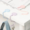 Pink and blue heavy duty purse and bag hooks for organization displayed on a white surface.