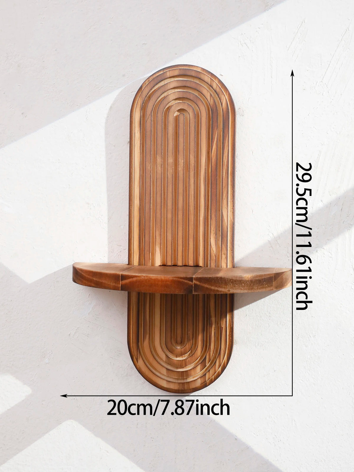 A vertical wooden wall shelf with a rounded, ribbed design mounted on a white wall.