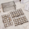 Clear acrylic jewelry organizer with three drawers displayed on a white fluffy surface.