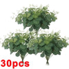 A bunch of artificial eucalyptus stems with green leaves and small white flowers.