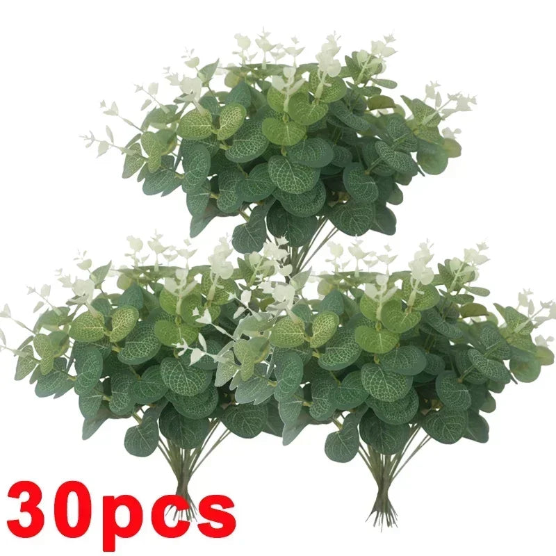 A bunch of artificial eucalyptus stems with green leaves and small white flowers.