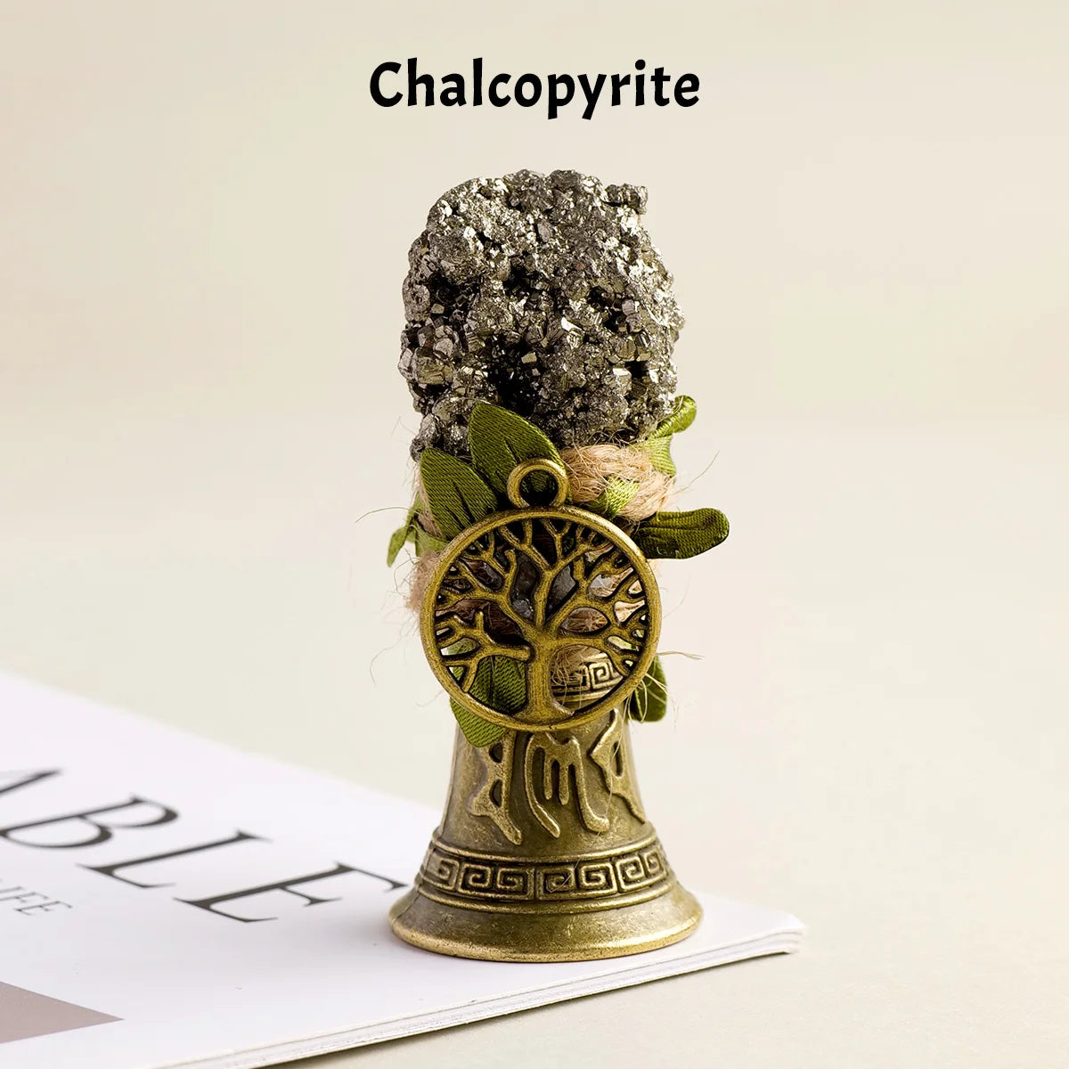 A natural crystal chalcopyrite mineral mounted on a brass bell with a copper finish.