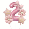 Pink foil balloons shaped like the number nine and flowers for a birthday celebration