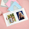 A pink and blue love heart photo album with two open pages displaying photos of a couple.