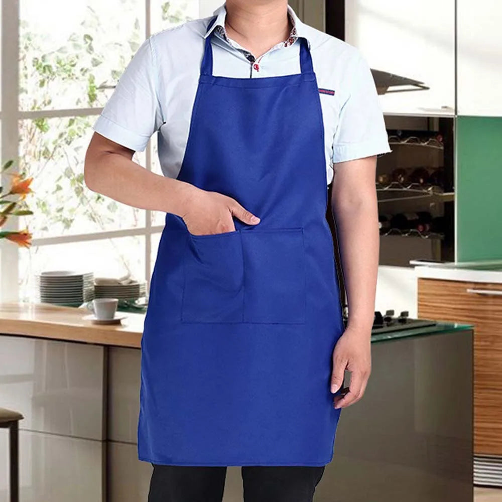 A person wearing a royal blue waterproof kitchen apron with a front pocket standing in a modern kitchen.