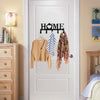 A white door features a black wall key holder with heart hooks and several clothing items hanging on the door.