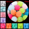 A collection of colorful textured resin beads in various shades and sizes, including pink, green, orange, blue, and purple.
