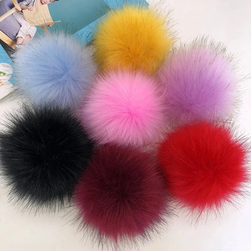 Collection de pompons en fausse fourrure colorés dans les tons de bleu, jaune, rose, violet et rouge.