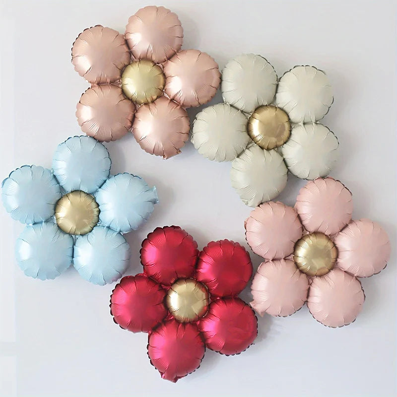 A set of five matte foil flower balloons in shades of red and pink with a daisy design.
