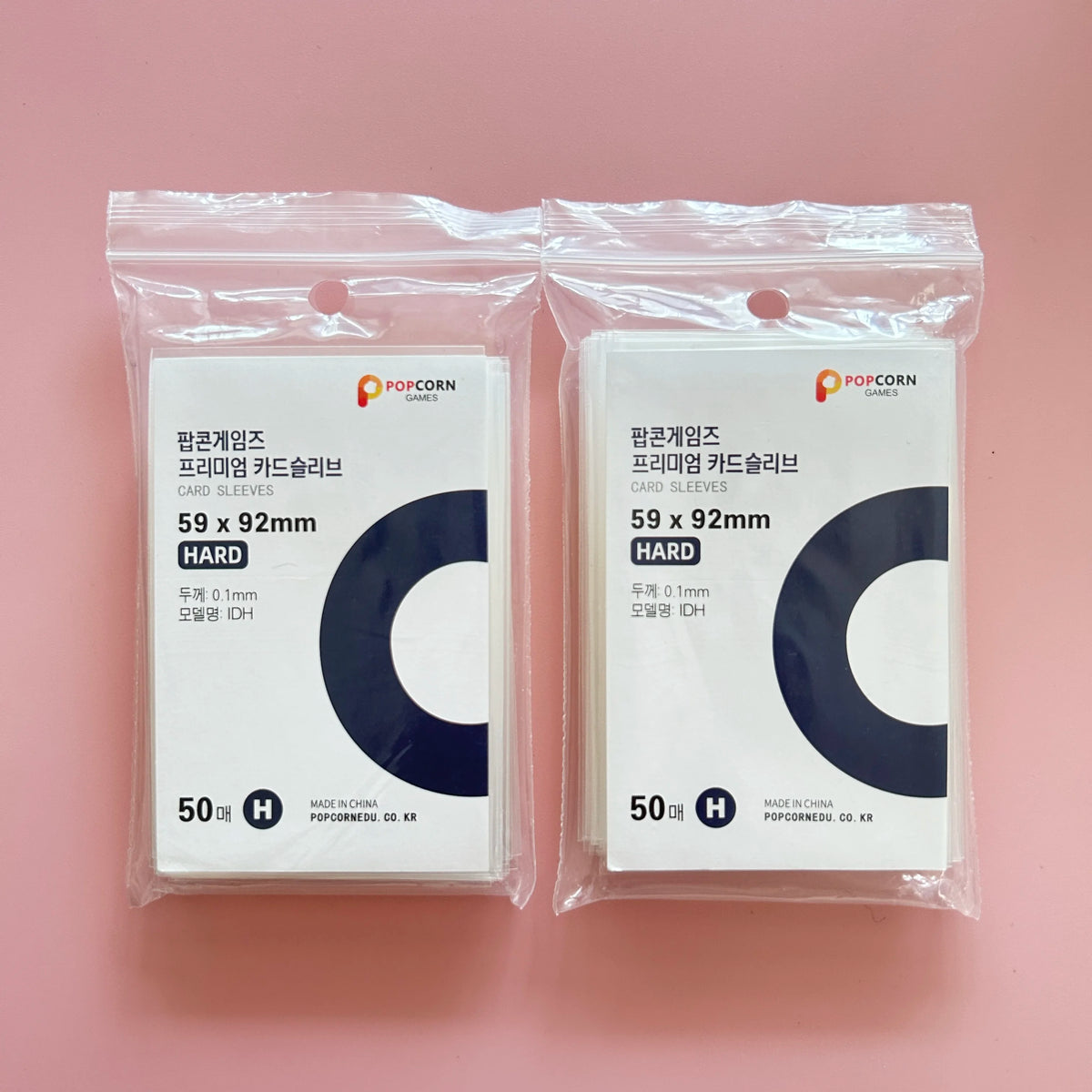Two sealed packages of POPCORN GAMES premium card sleeves, each containing 50 hard card sleeves.