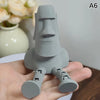 A hand holds a gray 3D printed Moai statue figurine with movable joints.