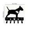 Black silhouette of a dog standing on decorative metal key hooks for wall organization.