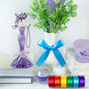 A collection of satin silk ribbons in various colors including purple, blue, orange, and green displayed on a white surface.