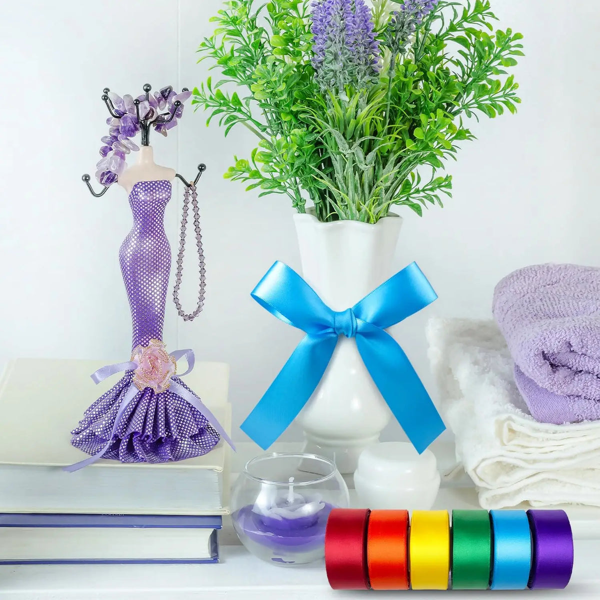 A collection of satin silk ribbons in various colors including purple, blue, orange, and green displayed on a white surface.