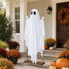 A large white ghost decoration hangs on a wooden frame near a front door and potted plants.