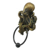 A bronze octopus skull door knocker featuring intricate detail and a cast iron ring.