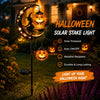 A solar stake light featuring a silhouette of a witch on a crescent moon illuminating a Halloween night garden.