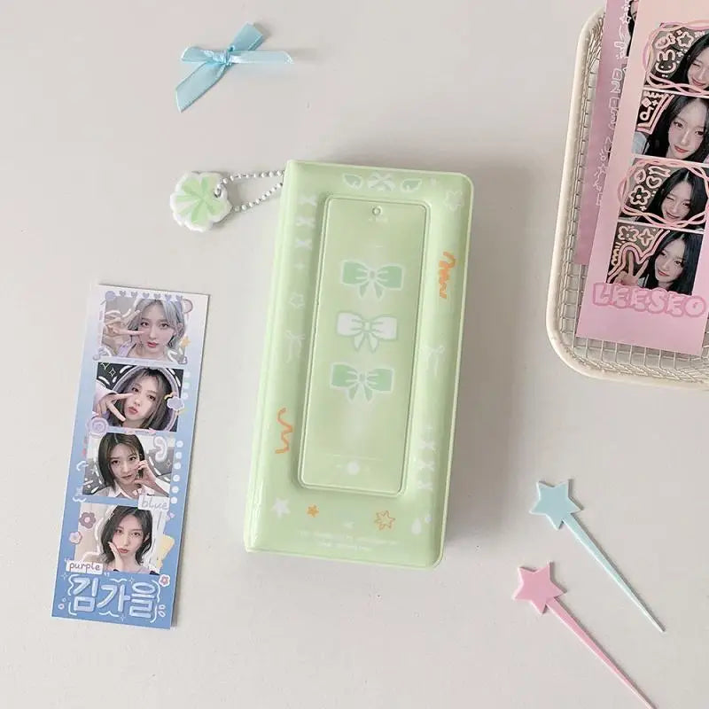 Un álbum de foto de color verde claro con diseño de cinta de mariposa y varias tarjetas de fotos, exhibido sobre una superfic