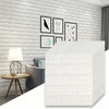 White 3D foam brick wallpaper panels displayed against a gray brick wall with framed art.