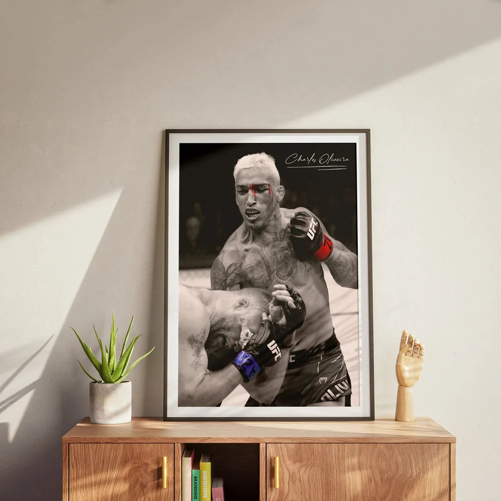 A framed black and white photograph of Charles Oliveira in a martial arts stance.