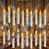 A display of glowing white LED floating candles suspended by wires, with a magic wand visible in the foreground.