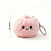 Pink fluffy butter dumpling squishy keychain charm with a smiling face