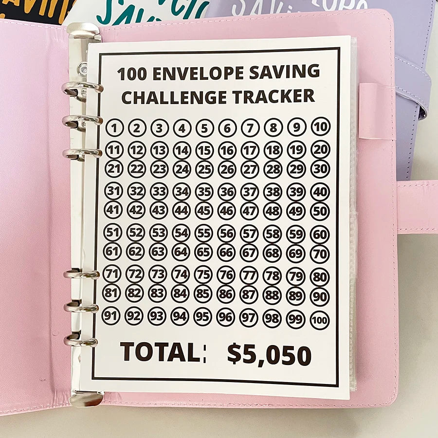 A pink binder for a 100 envelope savings challenge tracker with numbered pockets.