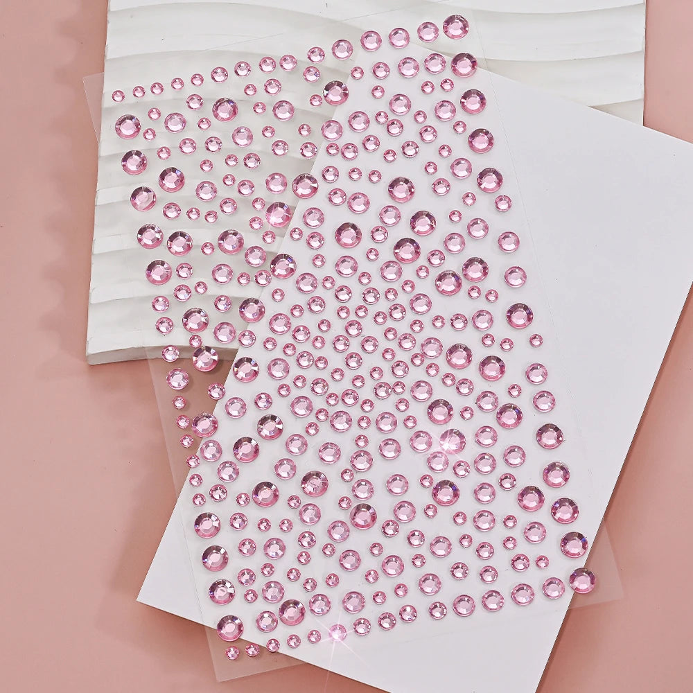 A close-up of pink glitter gems arranged in a diagonal pattern on white paper.