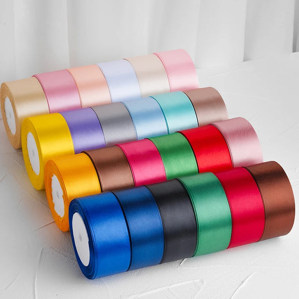 Un set de cintas decorativas de satén enrolladas en varios colores, incluyendo rosa, morado, amarillo, verde y rojo.