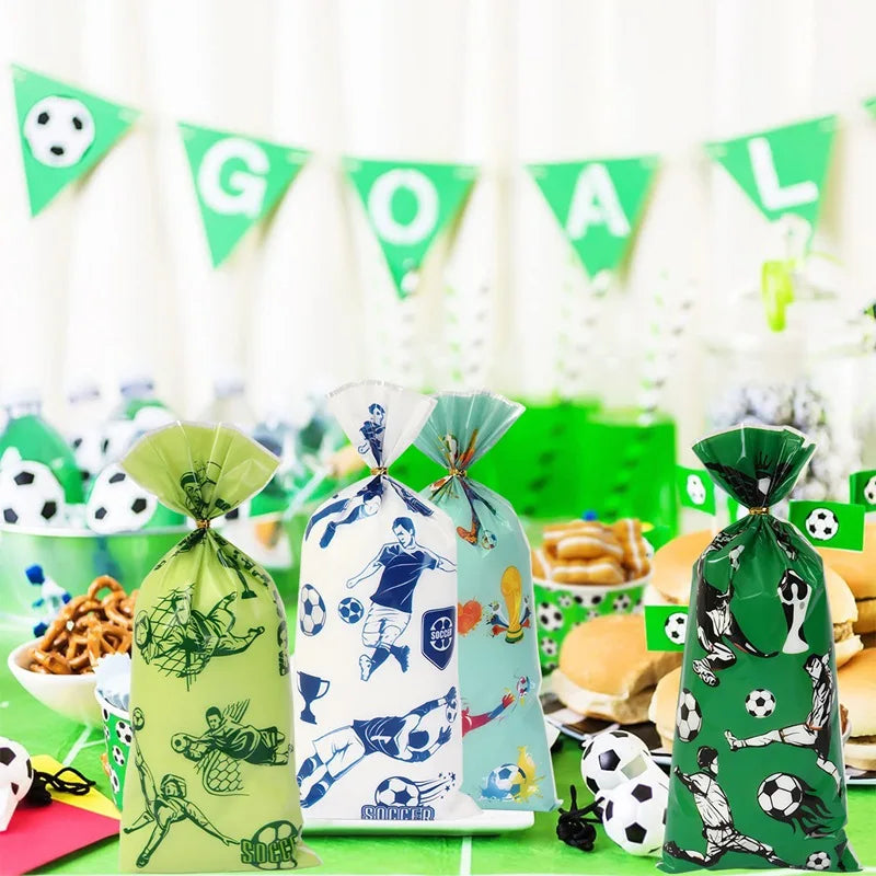 A set of soccer party supplies including a banner and green gift bags with soccer themes.