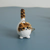 Handcrafted crochet cat keychain pendant with brown and white yarn texture