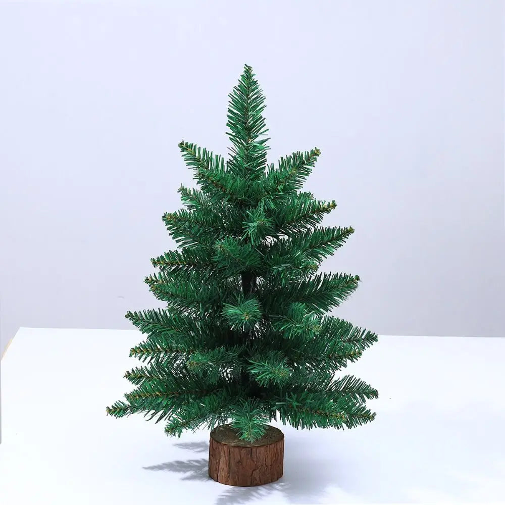 A small, green artificial Christmas tree with a warm glow displayed on a wooden base.