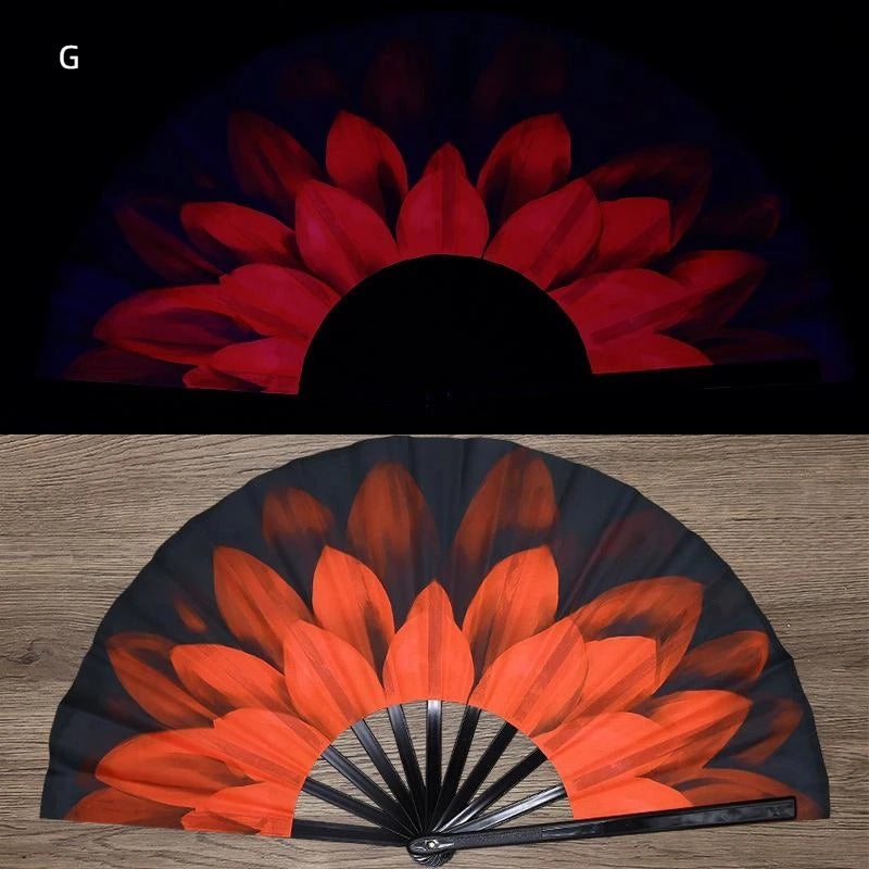 A folding fan with an orange and black floral design, shown in a semi-open, fan-like shape.