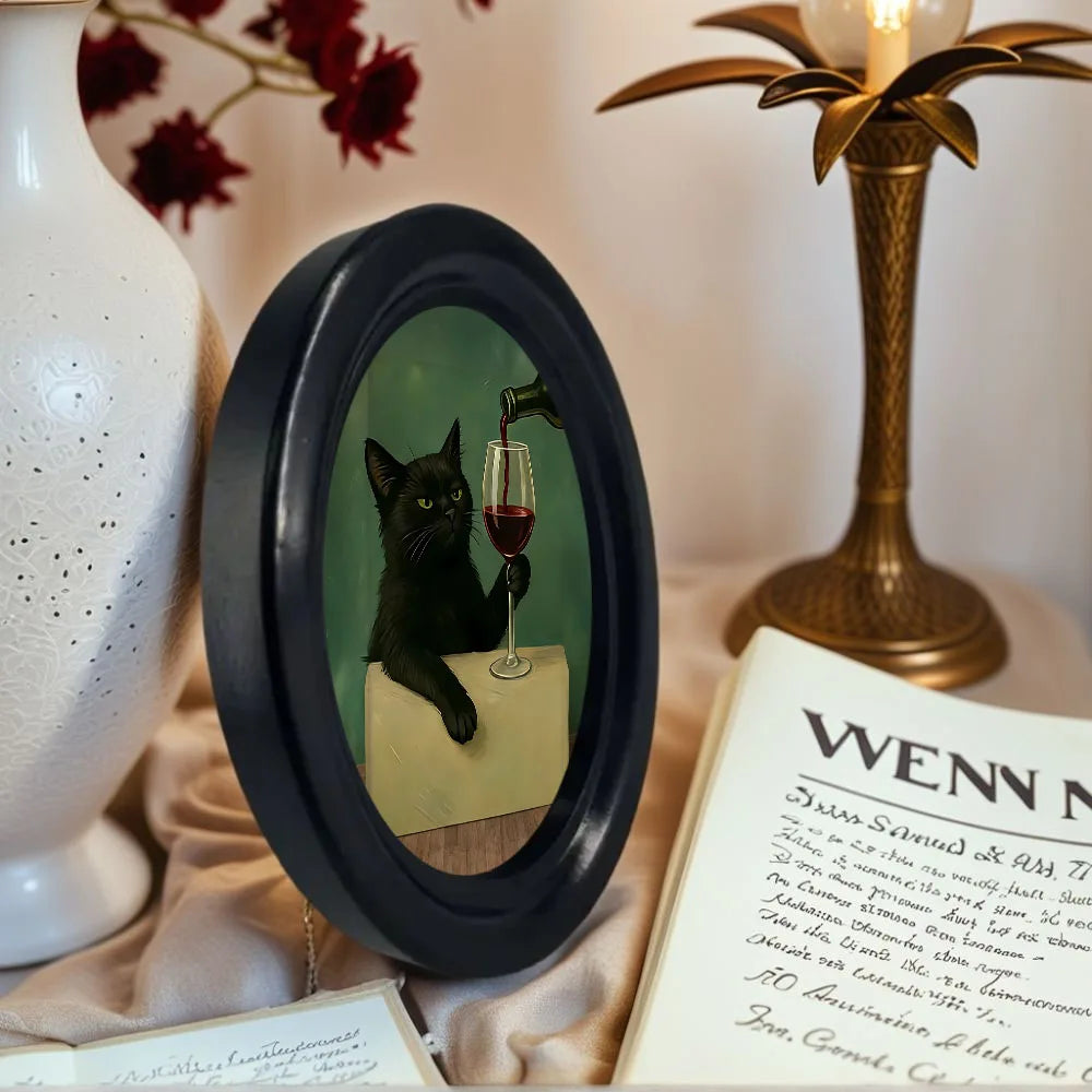 Wall art featuring a black cat drinking wine in a glass set against a dark green background.