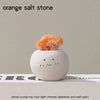 An orange salt stone resting on a white, smooth decorative stone.