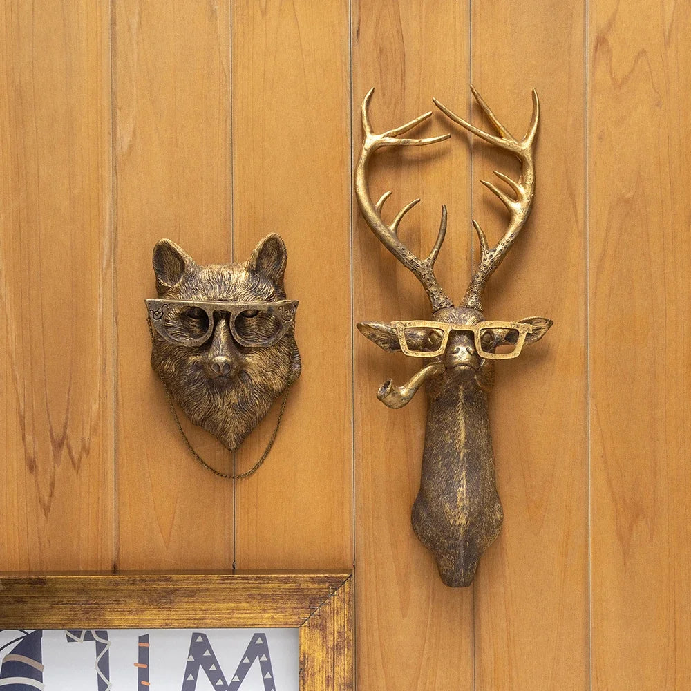 A brass deer head storage hook wall decor featuring antlers and glasses mounted on a wooden panel.