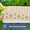 A beige waterproof elastic fitted tablecloth is being placed on a folding table outdoors.