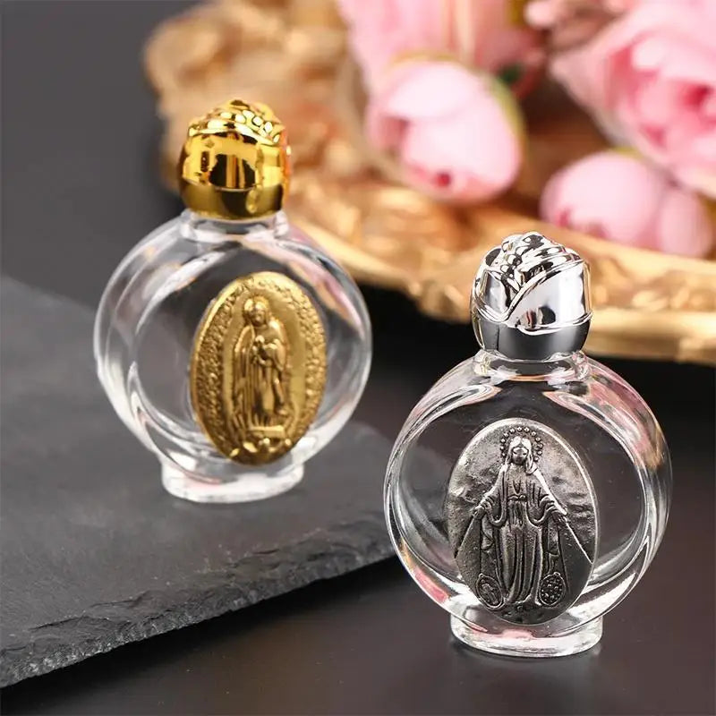 Clear glass holy water bottle with a gold religious sculpture inside