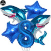 A collection of blue shark foil balloons and a blue number eight balloon for an ocean-themed party decoration.