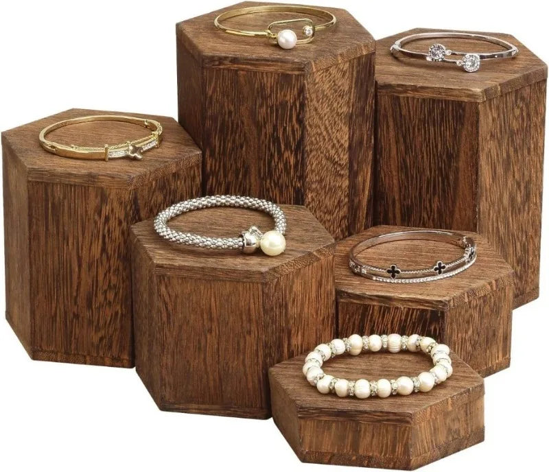 Wooden hexagonal display rack holding various gold and silver jewelry and accessories