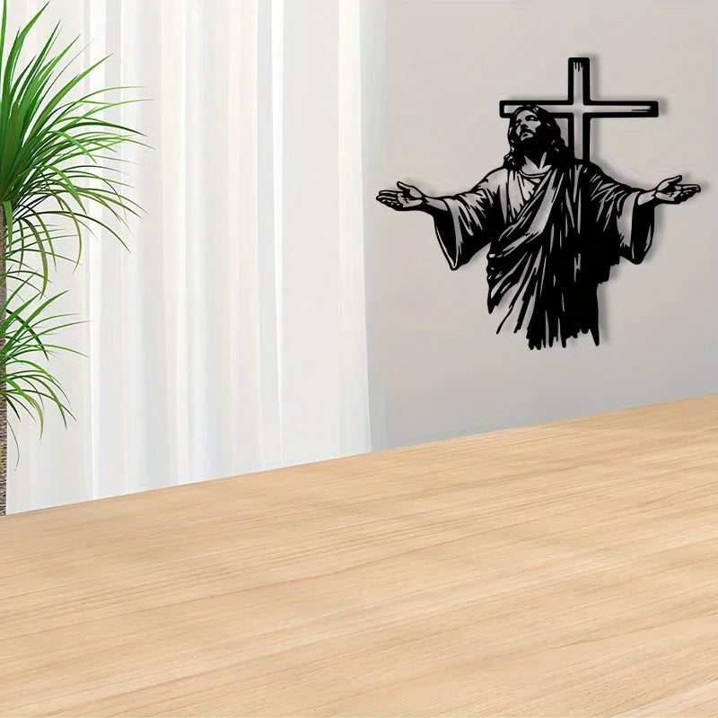Black silhouette of Jesus with outstretched arms and a cross on a gray wall.