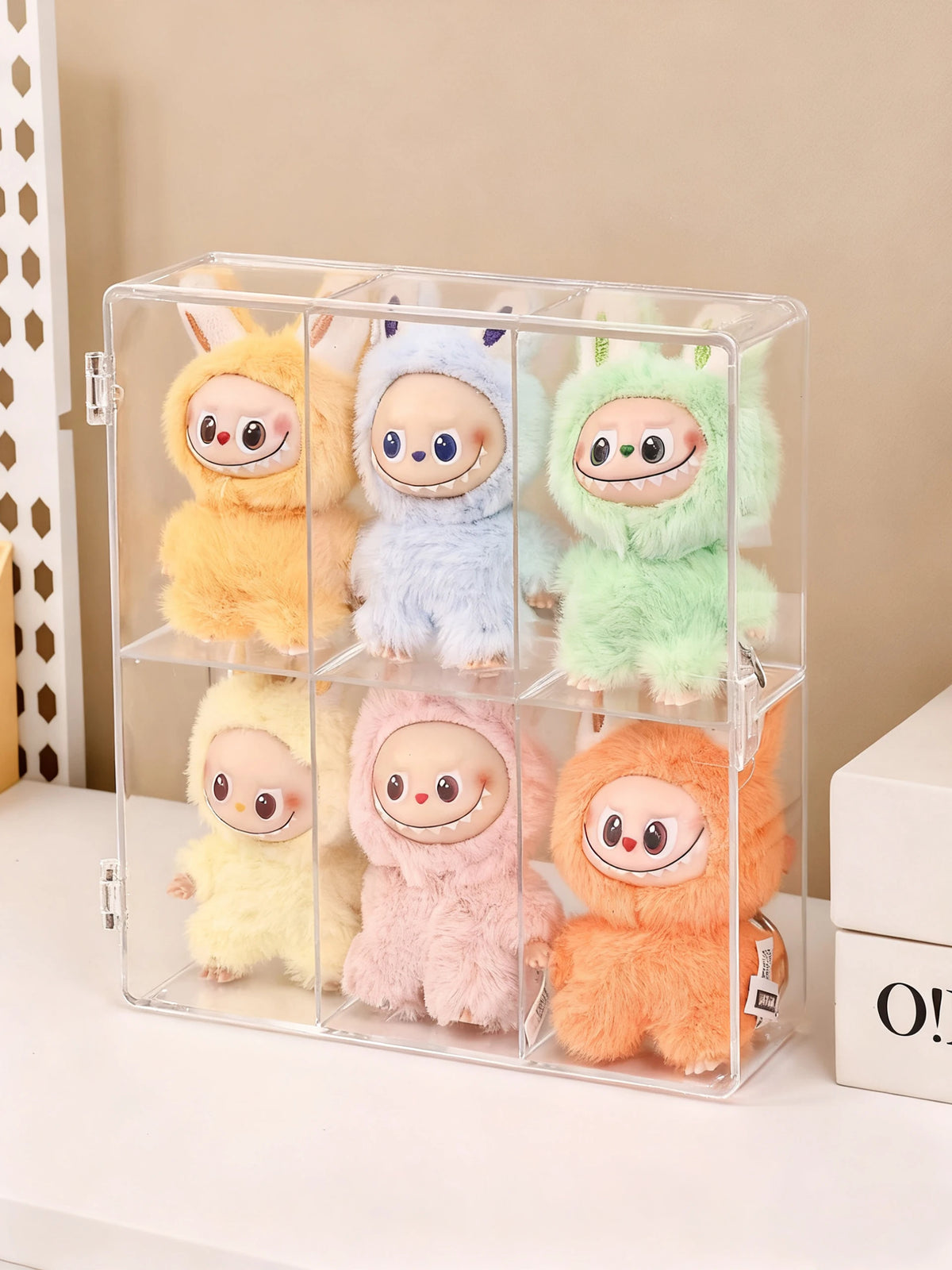 Klare Acryl-Blindbox-Präsentation mit vier flauschigen, süßen Tierfiguren in Gelb, Blau, Grün und Pink.