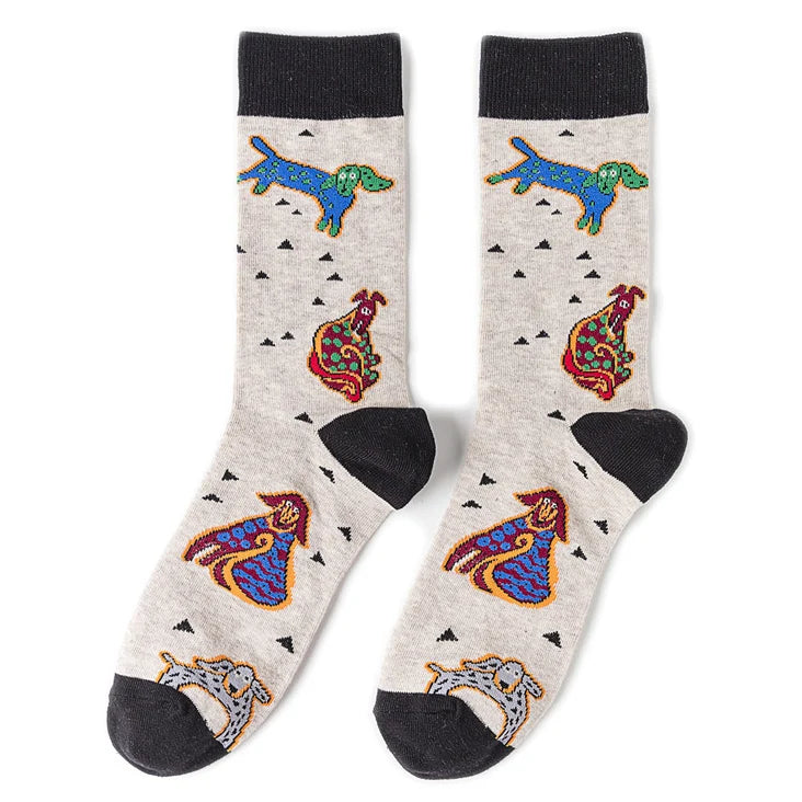 Pair of novelty crew socks featuring colorful prints of a blue alien, a red tiger, and a yellow skull on gray fabric.