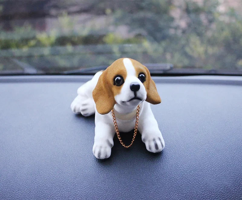 A small beagle puppy with white and brown markings is looking directly at the camera on a dark surface.