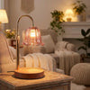 A brass adjustable height aromatherapy candle warmer lamp sitting on a wooden table in a cozy living room.